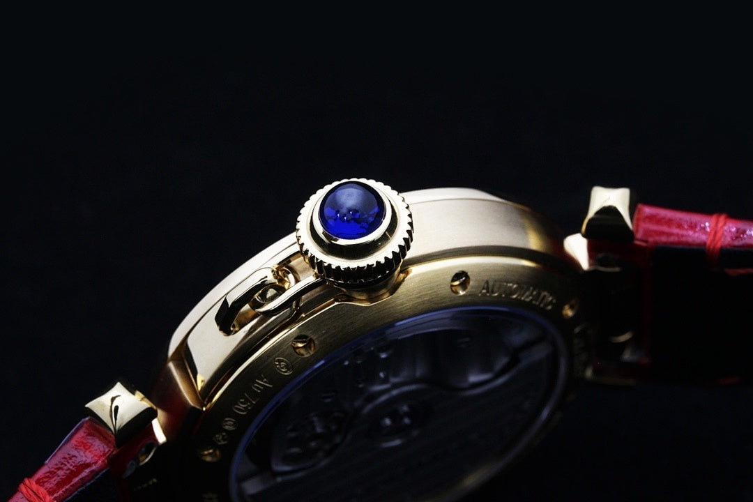 Cartier watch crown and blue jewel detail with red leather strap