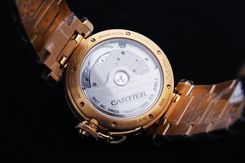 Gold wristwatch caseback with engraved markings and linked bracelet