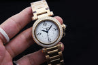Gold wristwatch with white dial, diamond bezel, blue hands, and linked bracelet