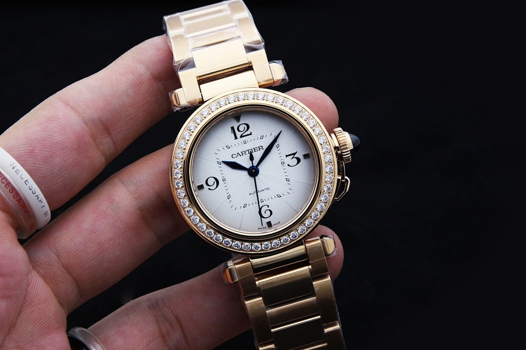 Gold wristwatch with white dial, diamond bezel, blue hands, and linked bracelet