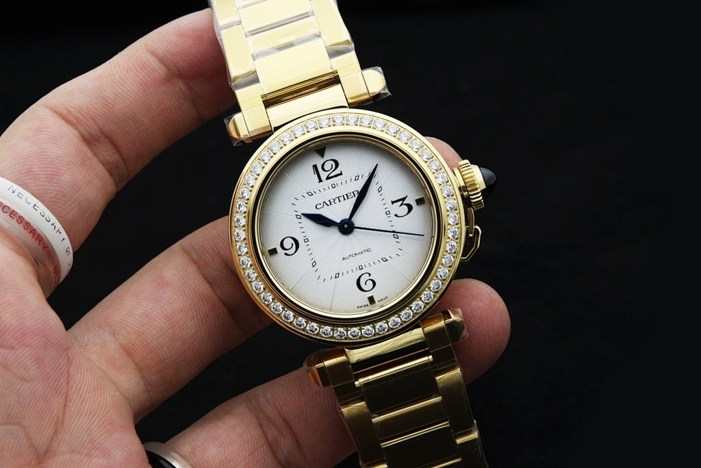 Gold-tone Cartier wristwatch with crystal-studded bezel, white dial, metal bracelet