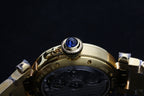 Gold-tone watch crown with blue cap and bezel detail, metal bracelet