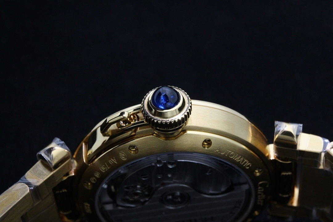 Gold-tone watch crown with blue cap and bezel detail, metal bracelet