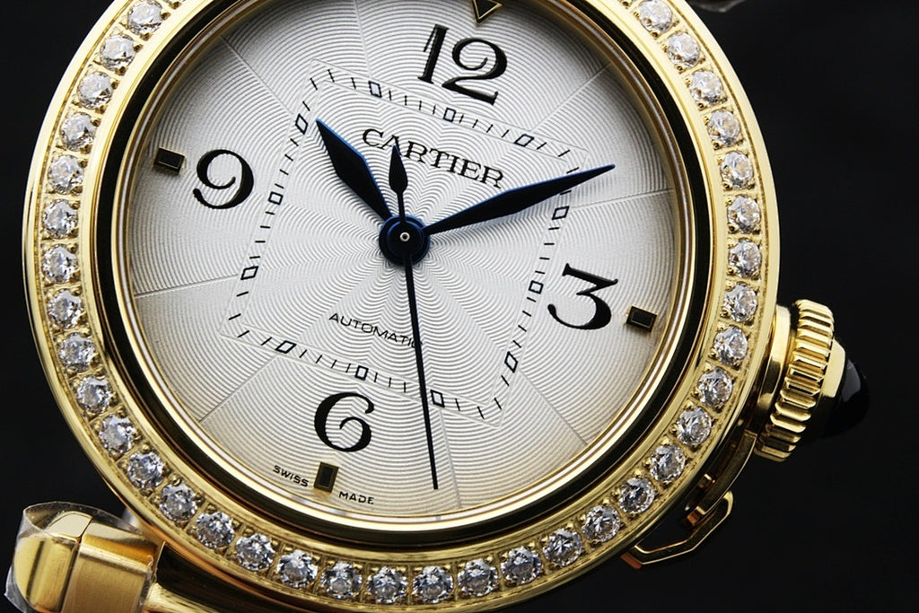 Gold-tone watch close-up with white dial, diamond bezel, black hour markers