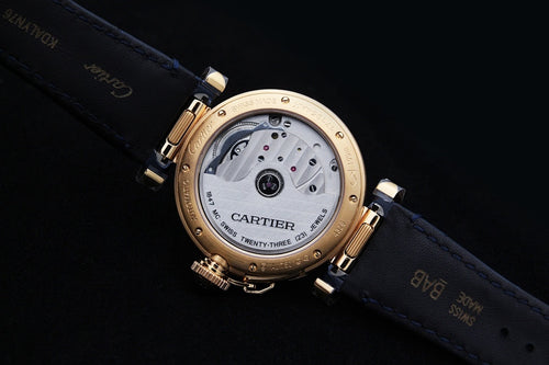 Gold-tone Cartier watch case back with dial detail, blue leather strap and clasp