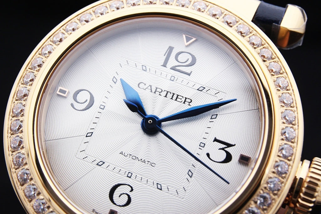 Cartier automatic watch with white dial, blue hands, diamond-studded gold bezel