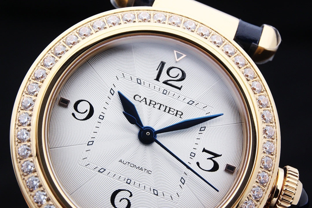 Cartier watch close-up with white dial, blue hands, diamond-studded gold bezel