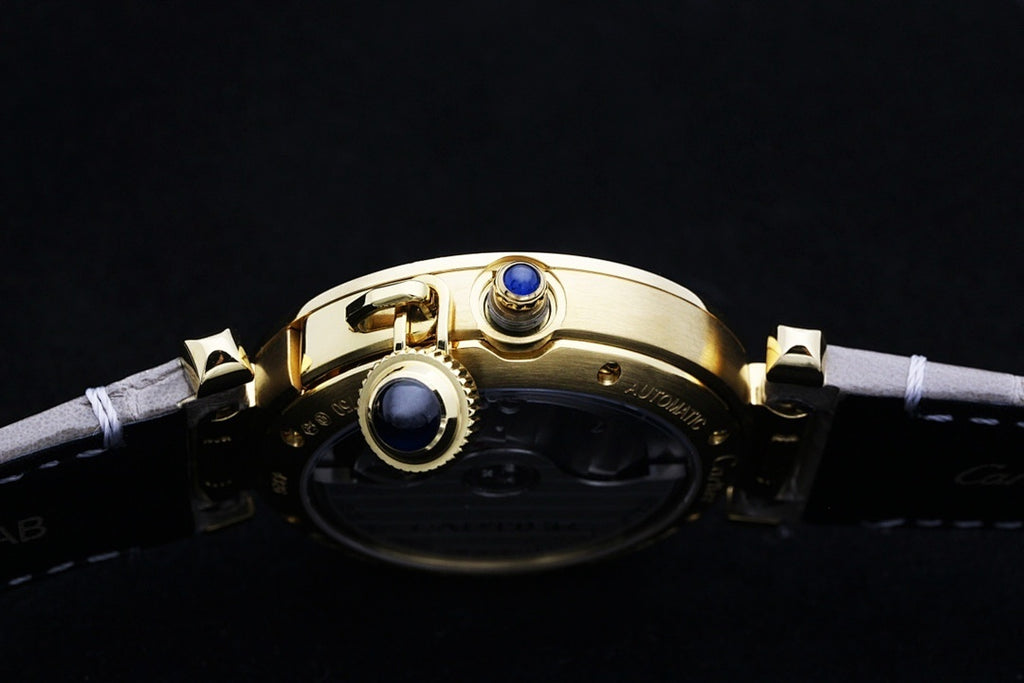 Cartier watch with gold case and blue crown accents on gray leather strap