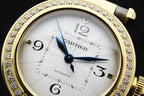 Cartier watch close-up with white dial, gold bezel with crystals, and blue hands