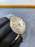 Silver diamond-bezel wristwatch with white Roman dial, subdial at 6 o'clock and metal bracelet