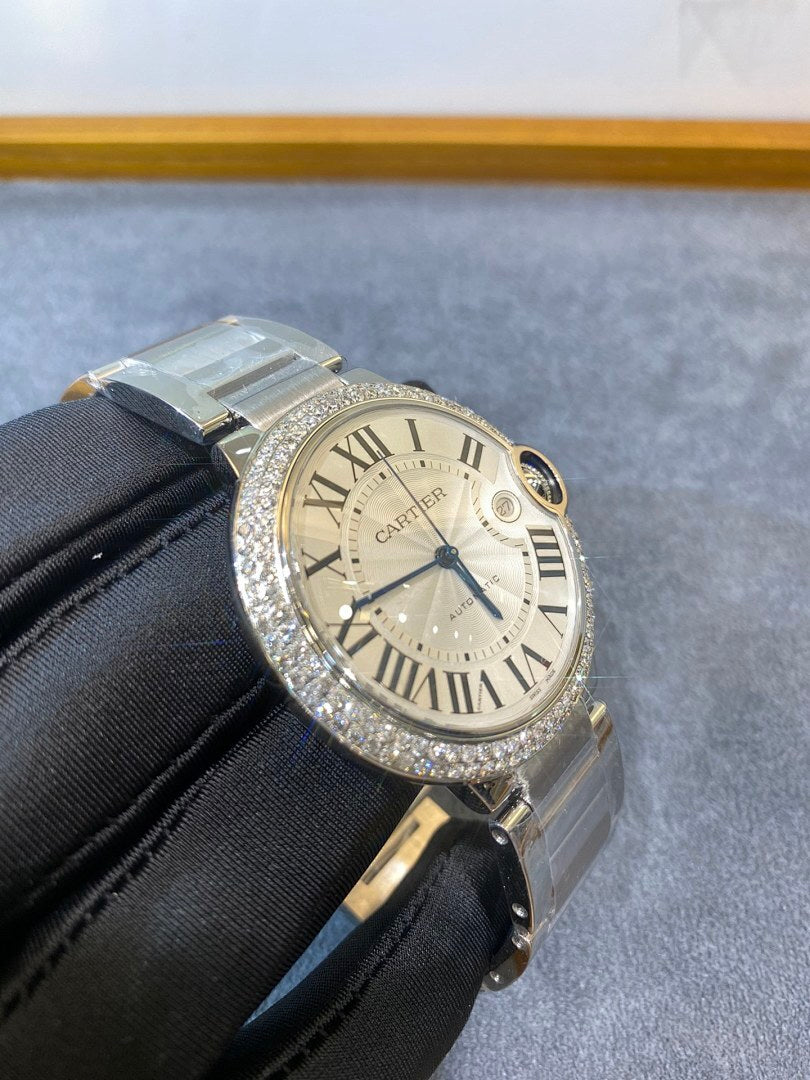 Silver diamond-bezel wristwatch with white Roman dial, subdial at 6 o'clock and metal bracelet