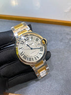 Cartier watch front view on black glove, white dial with Roman numerals, gold bezel