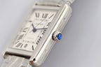 Cartier wristwatch dial close-up, Roman numerals and blue hands on silver face