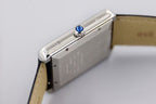 Rectangular stainless watch case with blue crown detail, black leather strap
