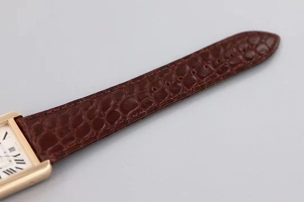 Dark brown crocodile-style leather watch strap, laid flat