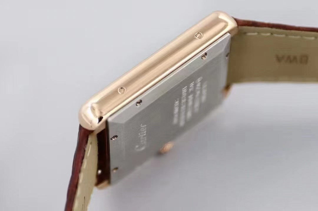Gold-tone watch side with crown and metal case edge, paired with dark brown leather strap