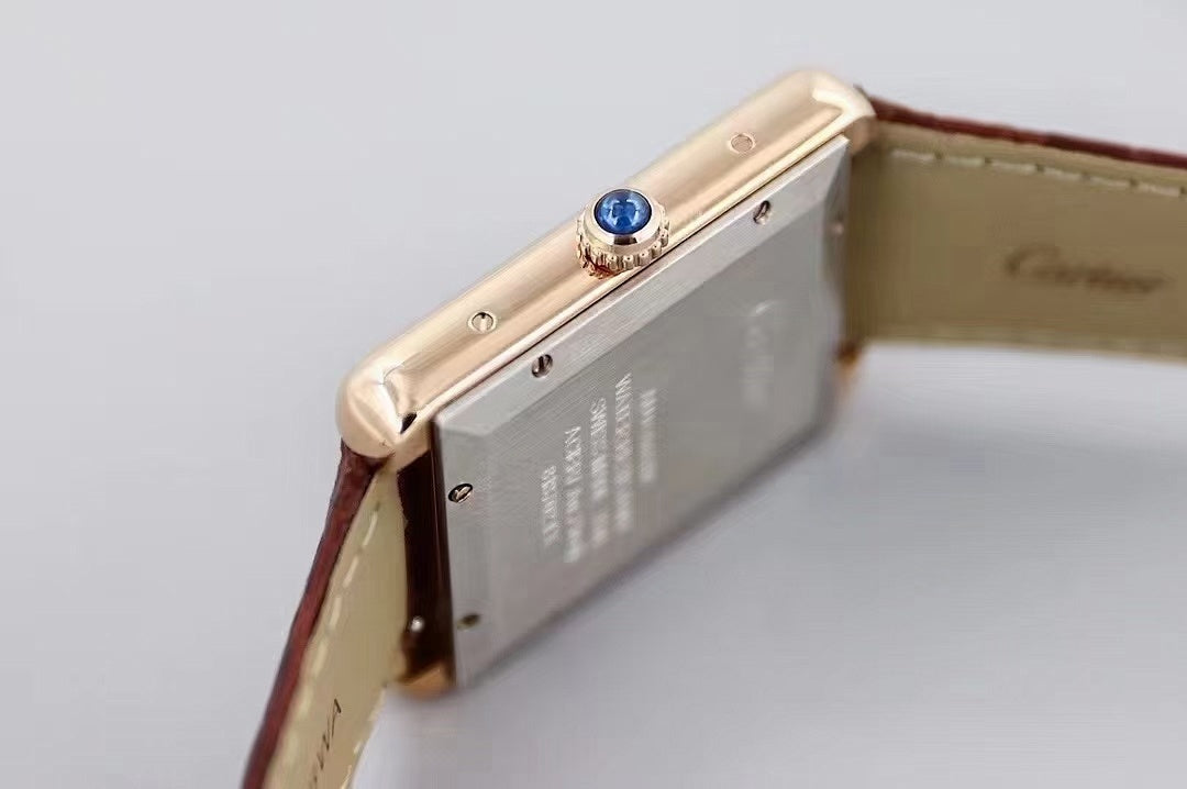 Gold-tone watch side with blue gem crown and metal case, paired with dark brown leather strap