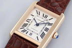 Rectangular Cartier wristwatch with white dial, black Roman numerals, and brown leather strap