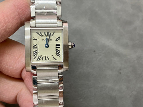 Cartier rectangular wristwatch with cream dial, Roman numeral marks, silver bracelet, blue crown.