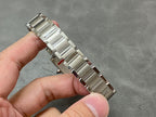 Cartier rectangular watch with silver metal bracelet, side profile view of the case.