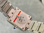 Cartier watch caseback with brushed metal finish and engraved markings, on metal bracelet.