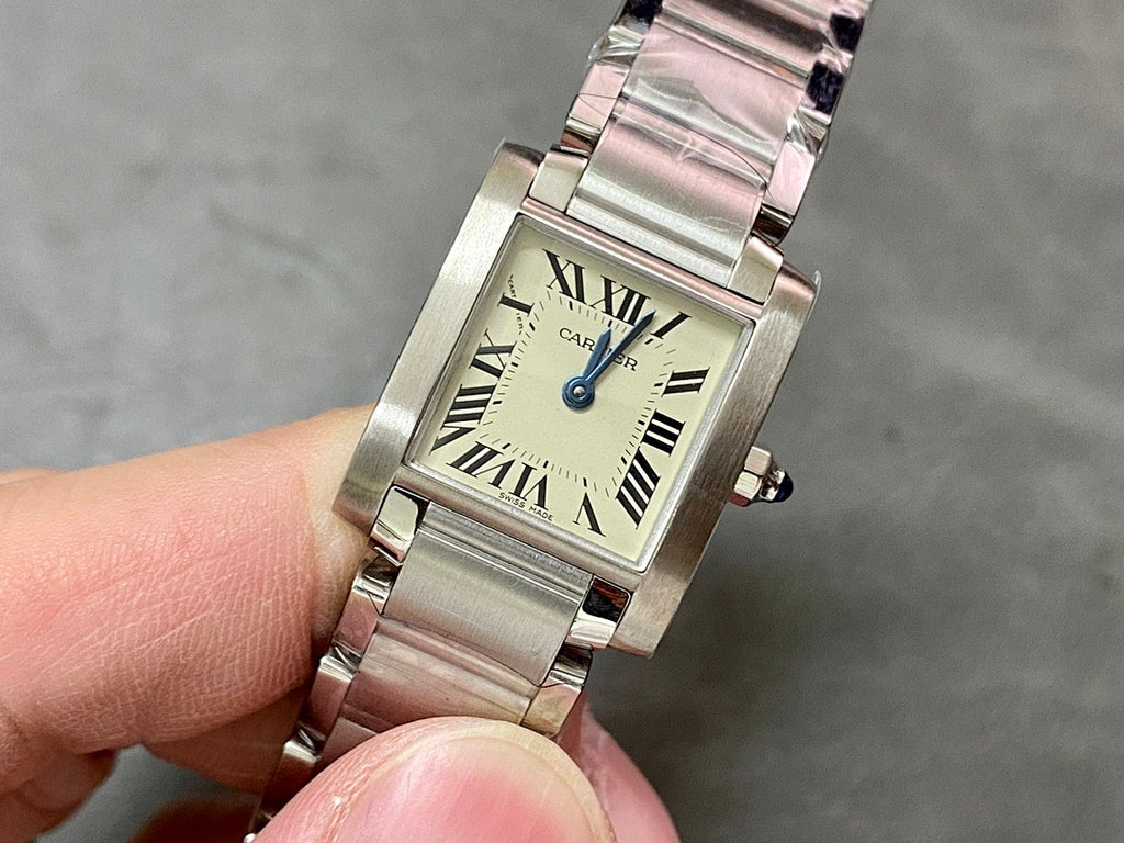 Cartier rectangular wristwatch with silver stainless bracelet, Roman numeral dial, blue crown.