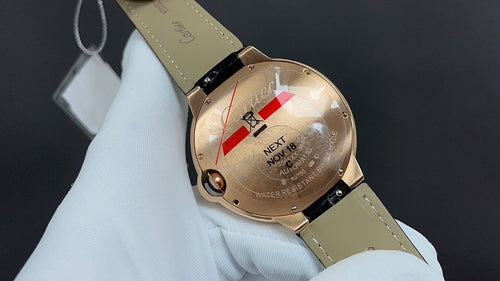 Cartier watch with gold-tone case, light dial, black leather strap, side crown detail