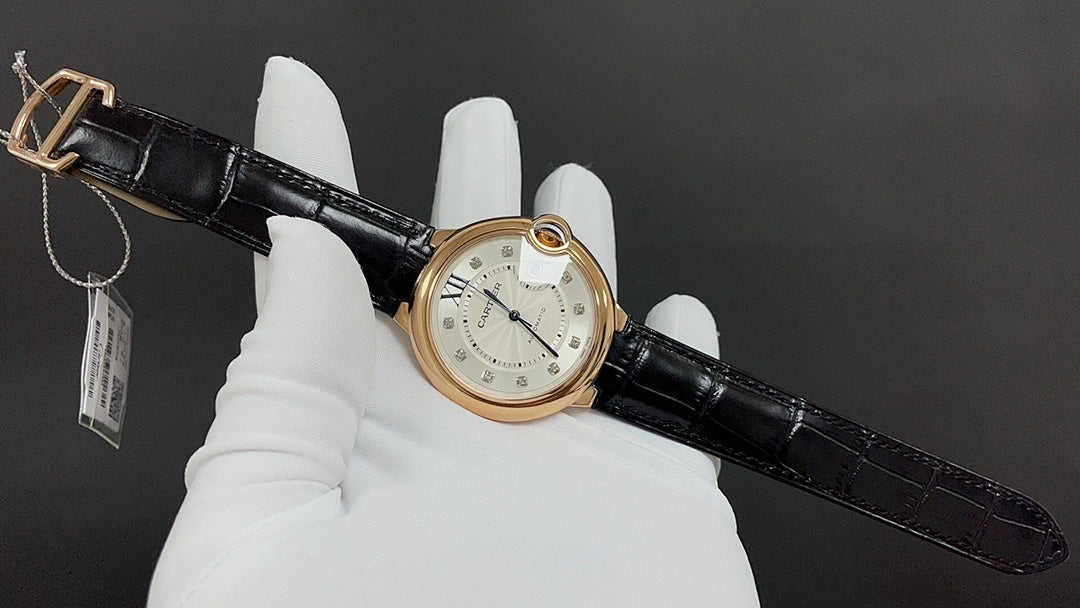 Cartier automatic watch with black leather strap and gold-tone case, front dial and crown