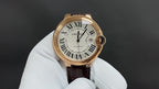 Cartier watch with gold-tone round case, Roman numeral dial, brown leather strap