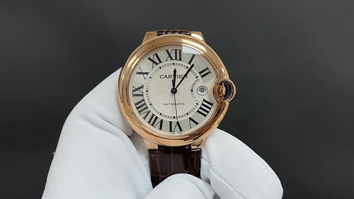 Cartier watch with gold-tone round case, Roman numeral dial, brown leather strap
