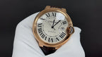 Cartier watch front view, gold-tone bezel, Roman numeral dial and leather strap