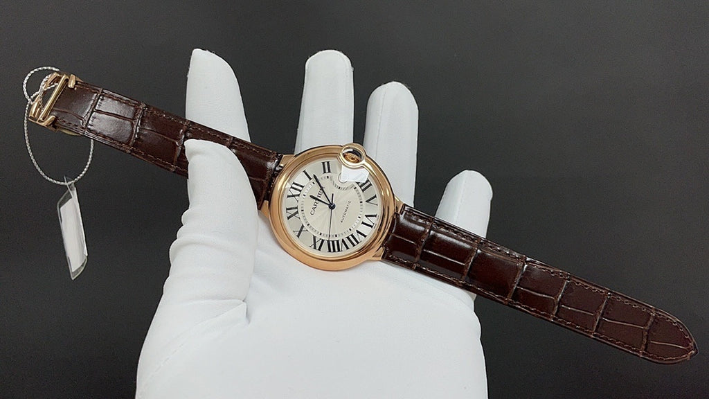 Cartier watch on brown leather strap with Roman numeral dial, circular gold case