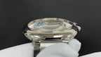 Cartier stainless steel watch with curved crystal and polished bezel, close-up front.