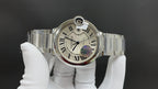 Cartier steel wrist watch with white dial, Roman numerals, blue hand, bracelet on glove.