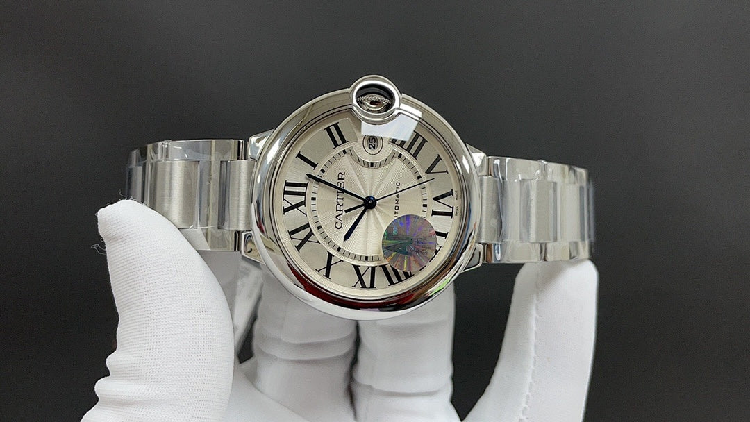 Cartier steel wrist watch with white dial, Roman numerals, blue hand, bracelet on glove.