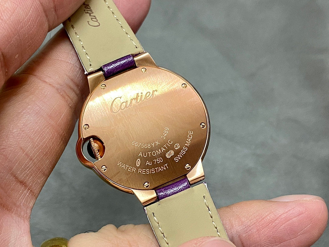 Cartier oval watch case back with purple strap, engraved details on gold-tone round back.