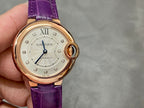 Cartier watch close-up with purple leather strap, cream dial, gold-tone bezel and crown.