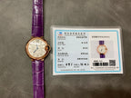 Cartier watch with purple leather strap and authentication card displayed nearby.