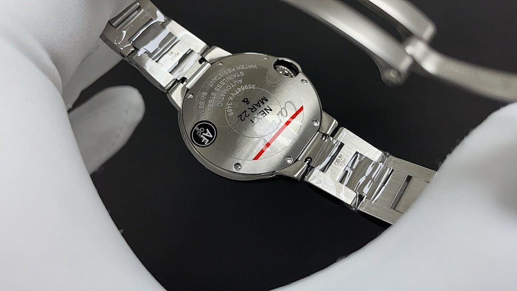 Stainless steel wristwatch bracelet and caseback detail, with crown and screws