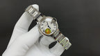 Stainless steel wristwatch with white dial and bracelet detail, angled profile