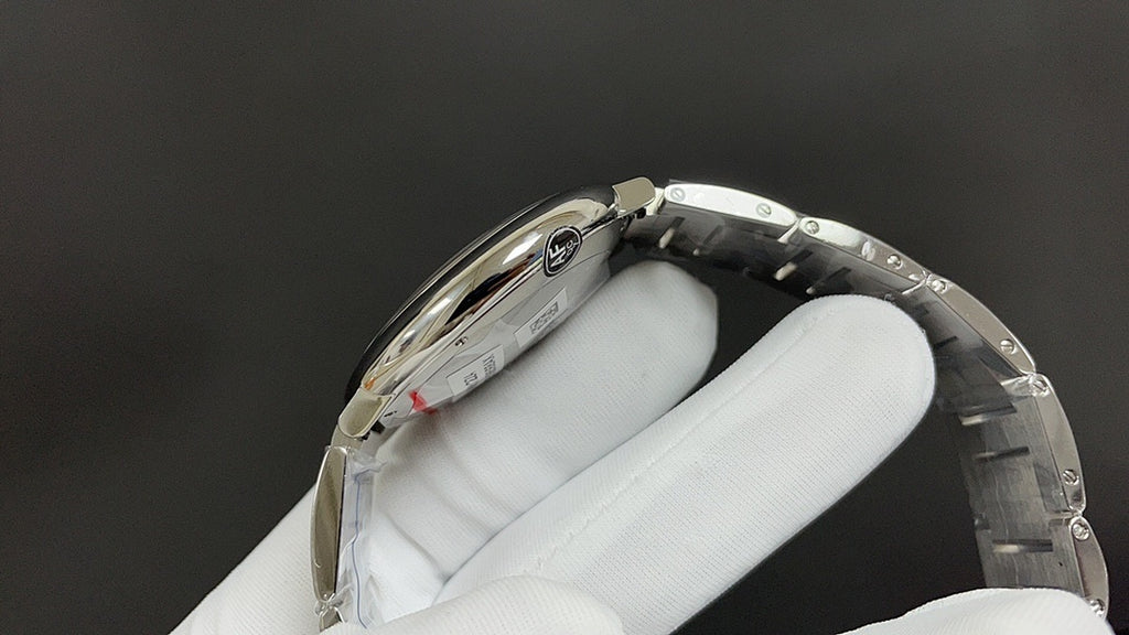 Wristwatch case back with metal bezel and bracelet links, angled view on white glove