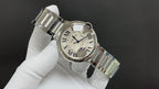 Wristwatch angled view, silver metal bracelet links and Roman numeral dial on white glove