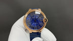 Cartier wristwatch front close-up with blue dial and rose gold bezel on white gloves