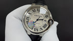 Cartier automatic wristwatch with black leather strap and Roman numeral dial, face close-up.