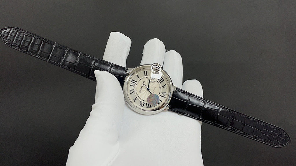 Cartier round wristwatch on black leather strap, Roman numeral dial and crown, side-on.