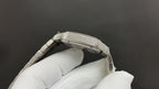 Cartier watch case side with diamond bezel and steel crown on glove
