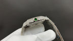 Cartier watch with green gemstone detail on diamond bezel and steel bracelet