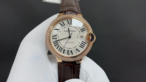 Cartier watch with gold-tone round case, Roman numeral dial, dark brown leather strap