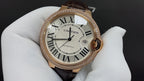 Cartier watch with gold-tone bezel, Roman numeral dial, dark brown leather strap