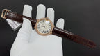 Cartier watch with gold-tone case, Roman numeral dial, dark brown leather strap and buckle